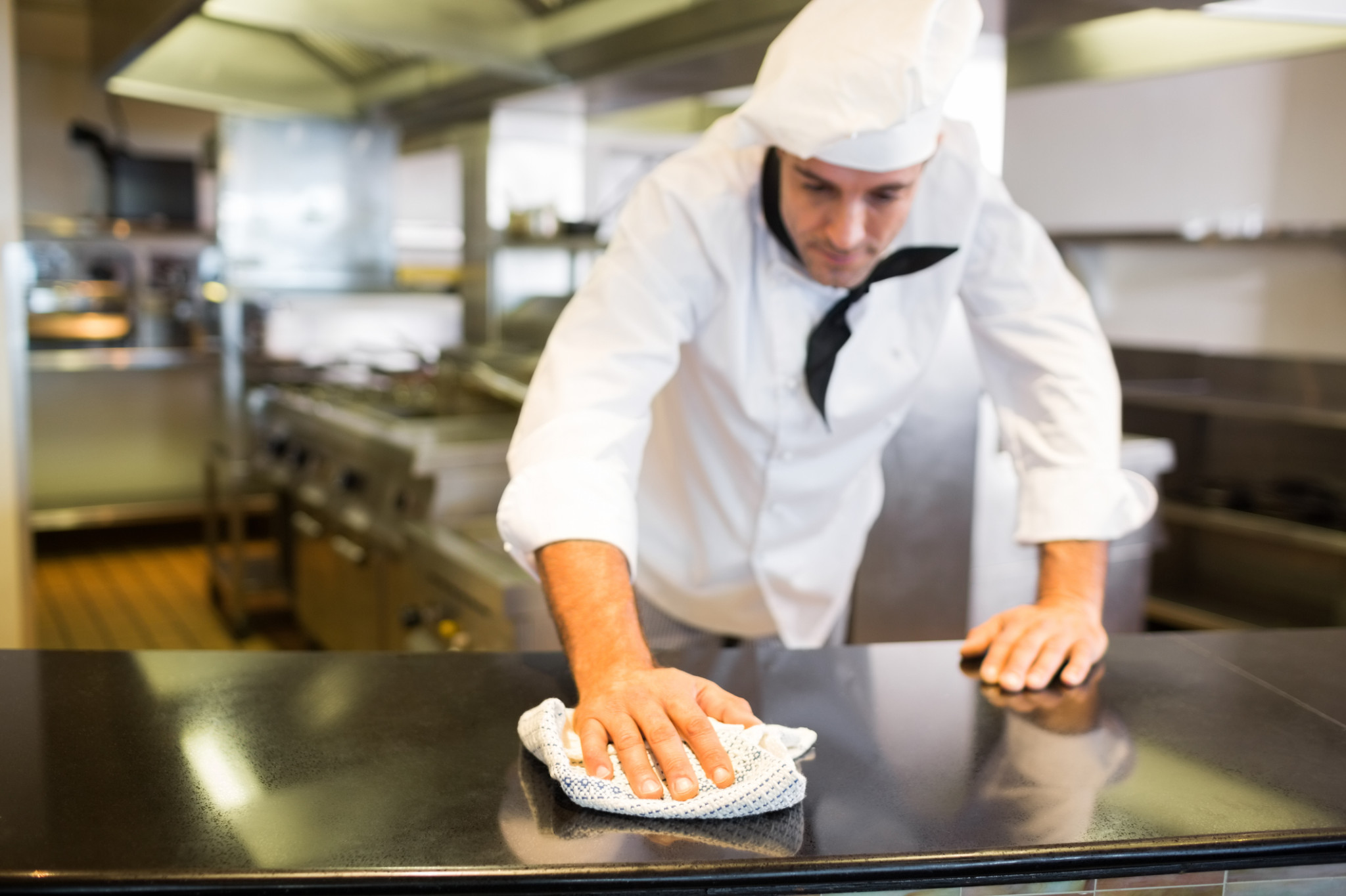Restaurant Insurance | Male cook wiping the counter top in the kitchen